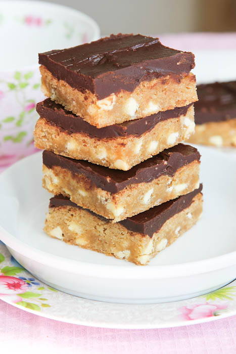 Stacked White Chocolate Blondies with Chocolate Peanut Butter Frosting on white plate