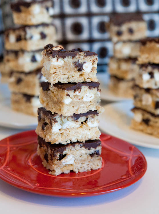 Stacked Chocolate Chip Cookie Dough & Marshmallow Stuffed Rice Krispie Bars on red plate
