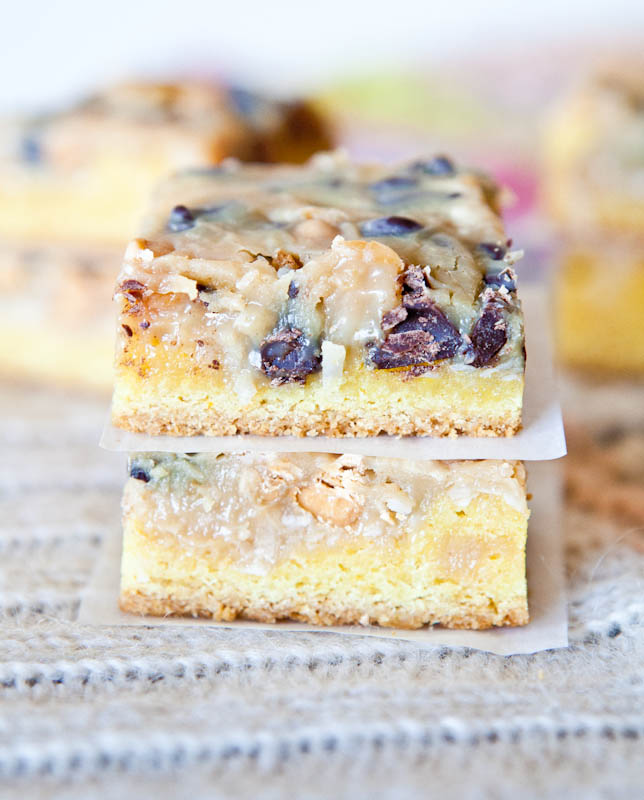 Two stacked Coconut Peanut Butter Magic Cake Bars separated by parchment paper