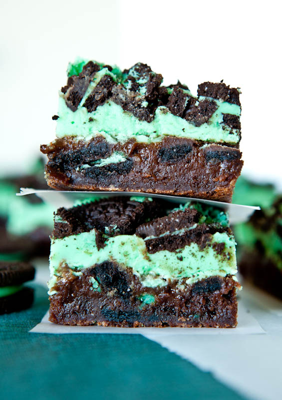 Two stacked Triple Layer Fudgy Mint Oreo Brownies separated by parchment paper
