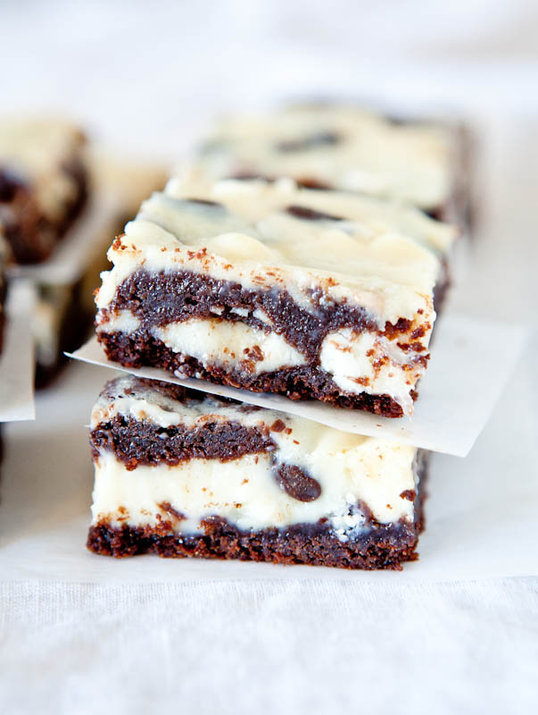 Two stacked White and Dark Chocolate Cream Cheese Chocolate Cake Bars separated by parchment paper