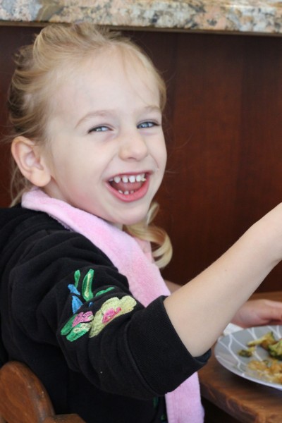 Young girl smiling while eating