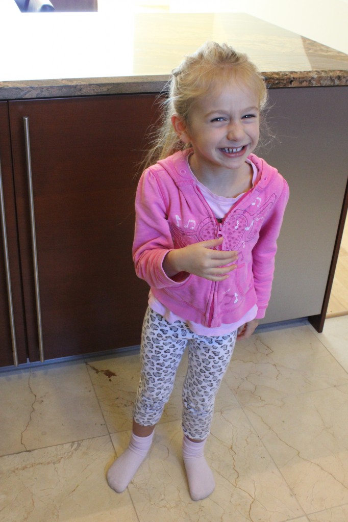 Young girl standing in kitchen smiling