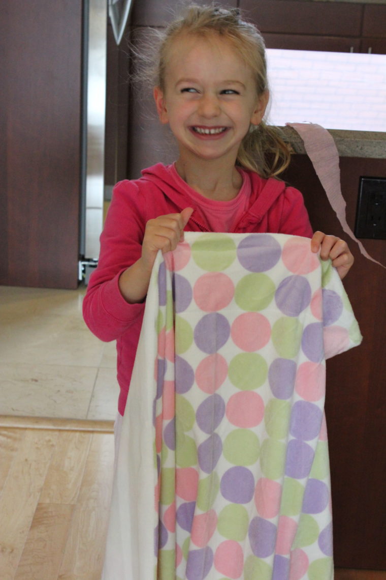 Young girl smiling and holding new blanket