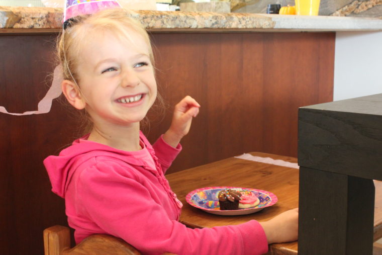 Young girl smiling eating birthday goodies