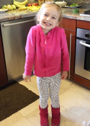 Young girl in pink in kitchen smiling