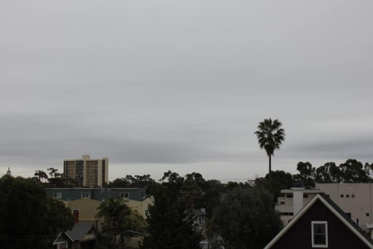 View from balcony showing clouds and buildings in background