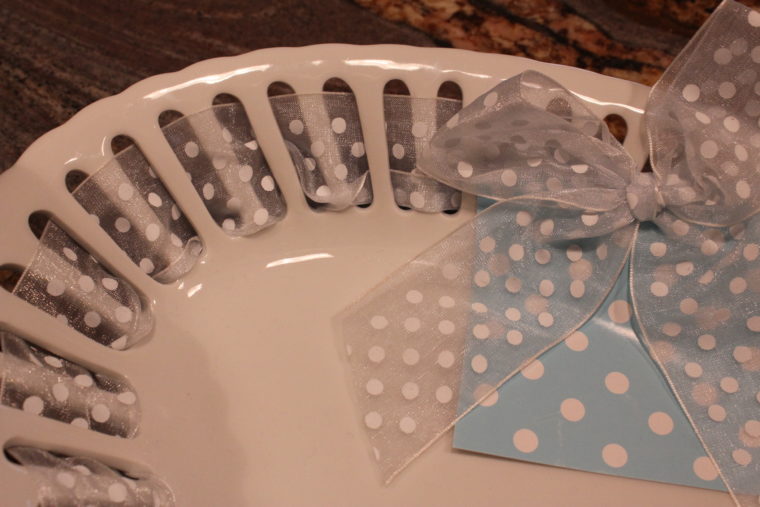 Close up of white dish with clear ribbon with polka dots