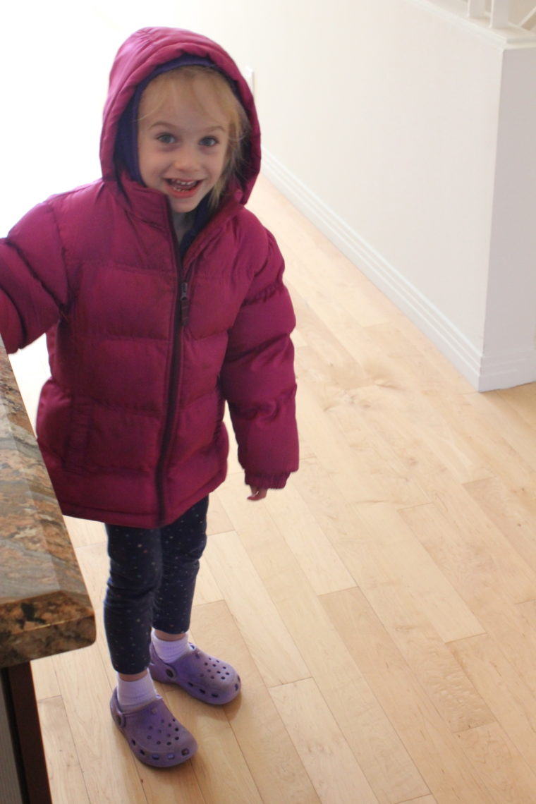 Young girl bundled up in puffy purple jacket