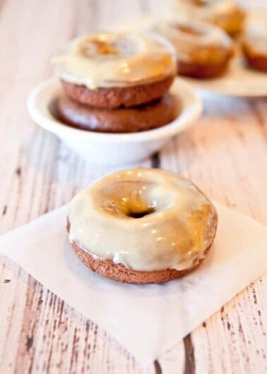 Glazed donuts on a rustic wooden table.