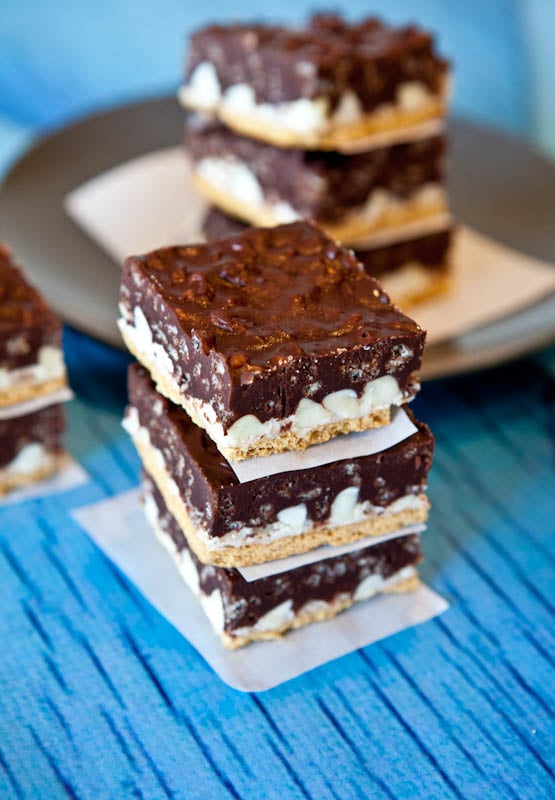 Peanut Butter Cocoa Krispies Smores Bars stack on blue table