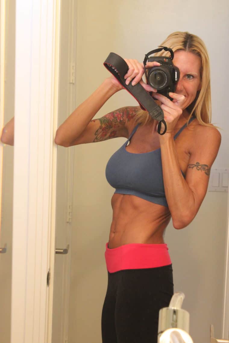 Woman taking photo of self in workout attire