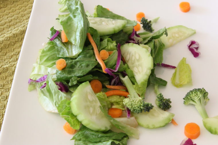 Green salad with vegetables on white plate