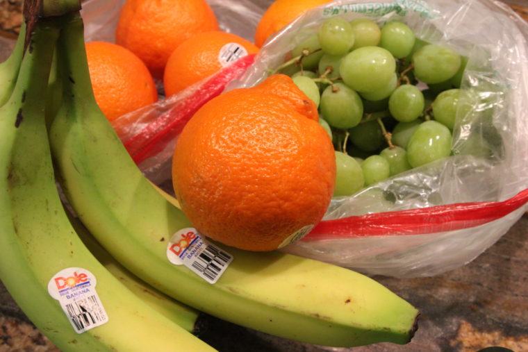 Close up of produce showing bananas, oranges and grapes
