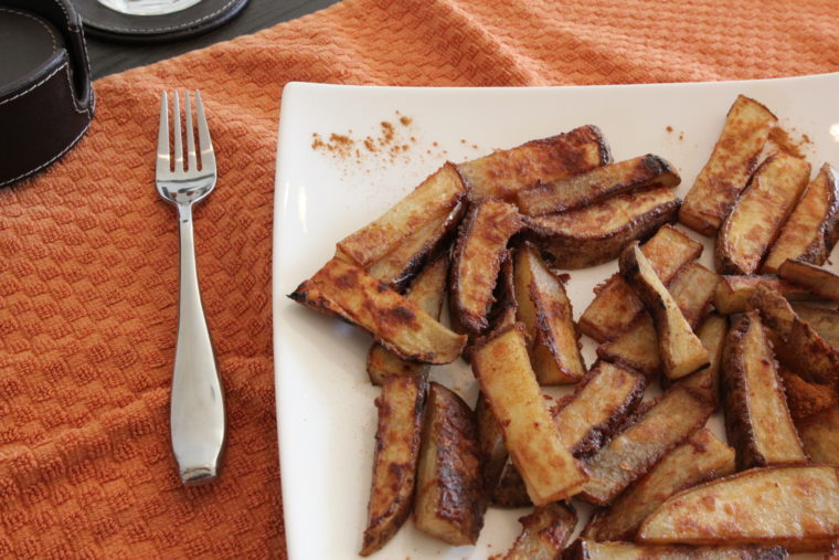 Cinnamon-Sugar and Ginger-Roasted Potato Sticks on white plate with fork