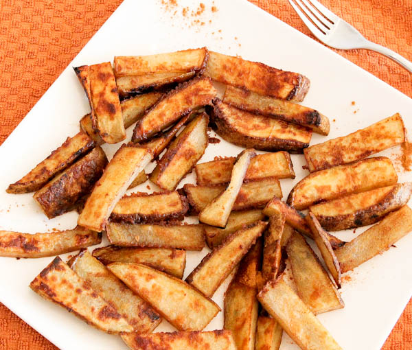 Layered Cinnamon-Sugar and Ginger-Roasted Potato Sticks on white plate