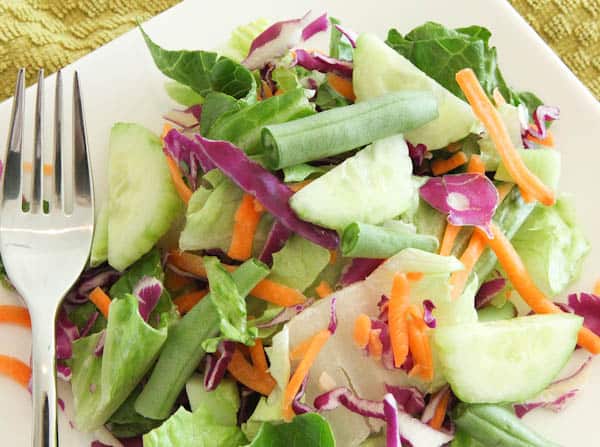 Mixed salad with vegetables on plate with fork