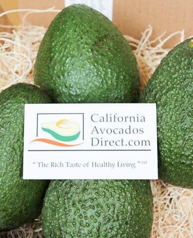 Fresh california avocados in a box with a promotional label.