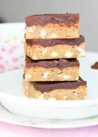 A stack of chocolate-topped peanut butter bars on a white plate.