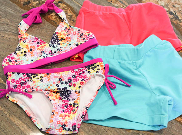 pink and blue shorts and purple floral patterned swimsuit