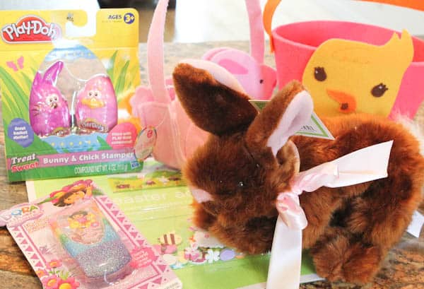 Easter basket supplies: brown fluffy bunny, PlayDoh stamps, duck basket, bunny basket, and dora phone