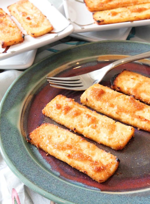 Four slices of tofu on plate with fork