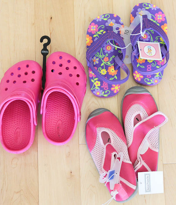 Pink crocs, purple flip flops, and pink shoes