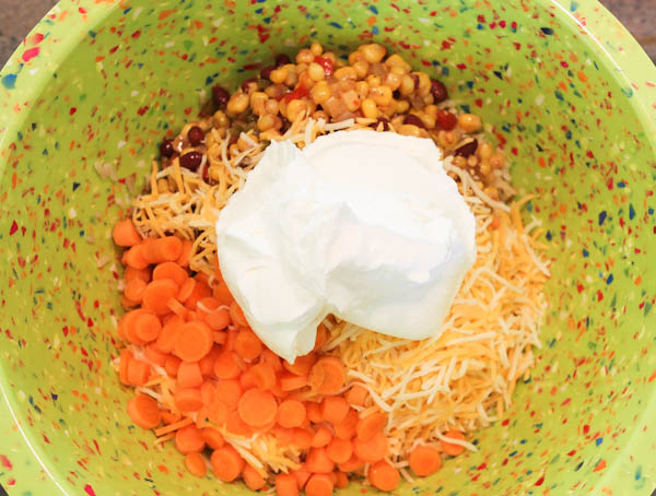Carrots, corn, and cheese in green bowl