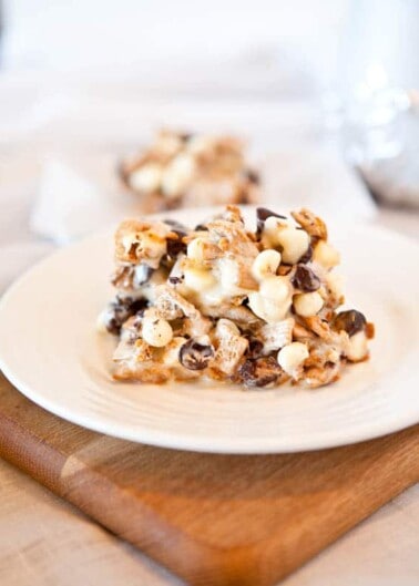 A plate with a stack of marshmallow cereal bars with chocolate chips on a wooden table.