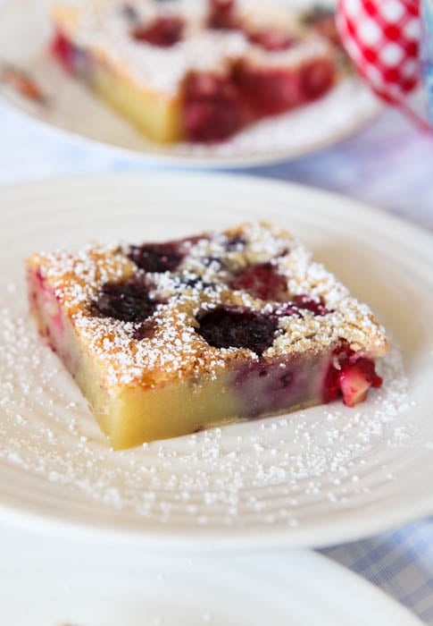 Mixed Berry Clafoutis on white plate with powdered sugar