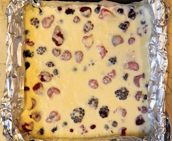 Unbaked Mixed Berry Clafoutis in foil lined pan