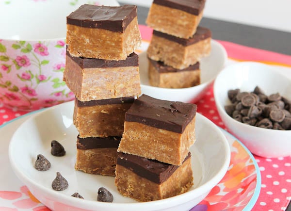 No Bake Nutella & Peanut Butter Graham Bars with Chocolate Frosting stacked on white dish