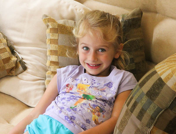 Young girl relaxing on couch laying back on pillow