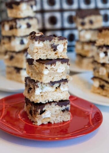 Krispy Treat bars stacked on plates with Chocolate Frosting