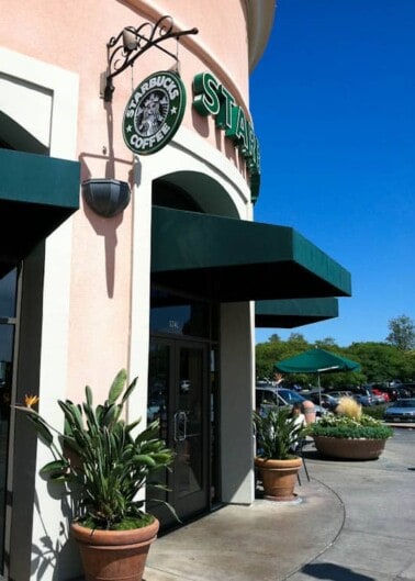 Exterior view of a starbucks coffee store with clear skies above.