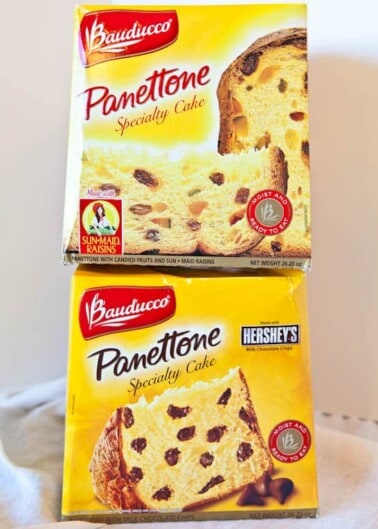 Two boxes of bauducco panettone specialty cake, one with candied fruits and sun-maid raisins, and the other with hershey's chocolate chips.