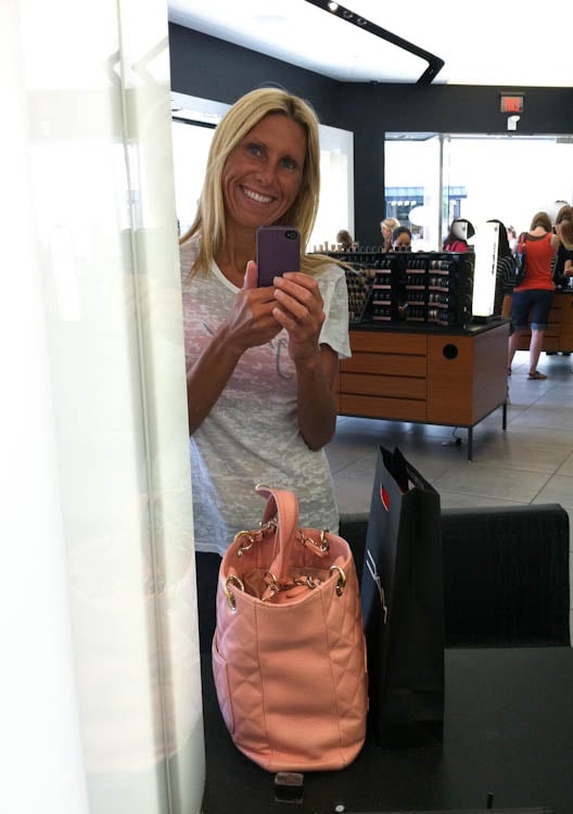 averie taking picture in store mirror with pink purse and mac bag in front of her