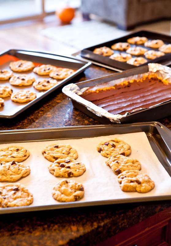 Pan of bars and three pans of cookies on marble countertop 