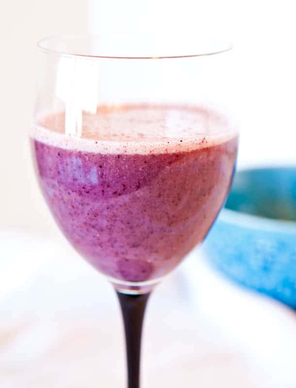 Blueberry Banana Recovery Smoothie in wine glass with black handle