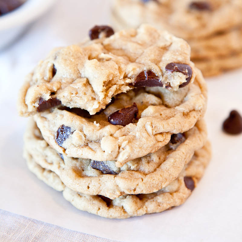 A stack of chocolate chip cookies on a white surface.