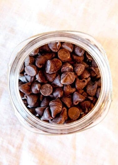 A glass jar filled with chocolate chips, viewed from above.