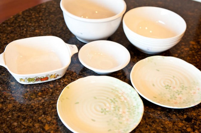 Thrifted white bowls and pans, three in front with floral patterns