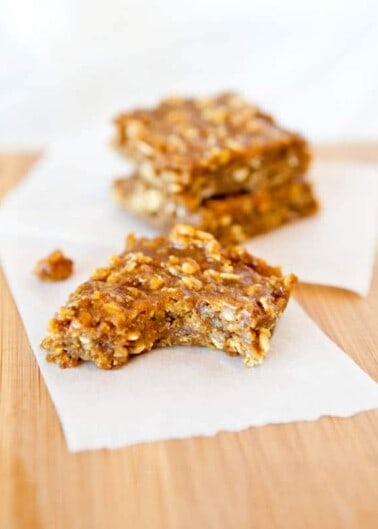 Two homemade granola bars on a piece of parchment paper.