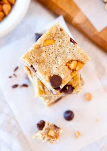 Homemade blondies stacked with chocolate chips and nuts.