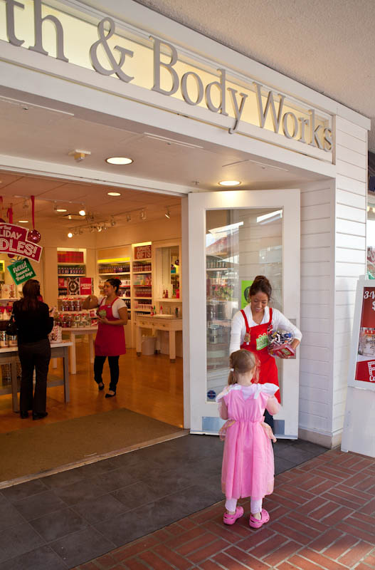 Skylar getting candy from an employee at the bath and body works storefront