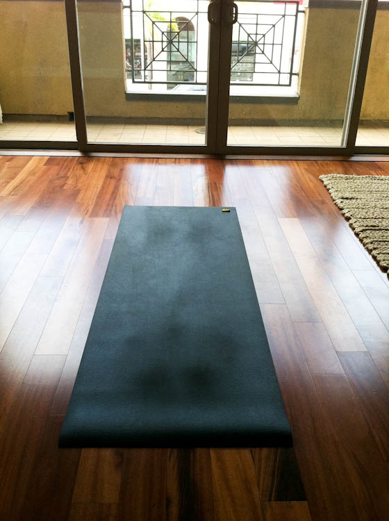 Black yoga mat on hardwood floor