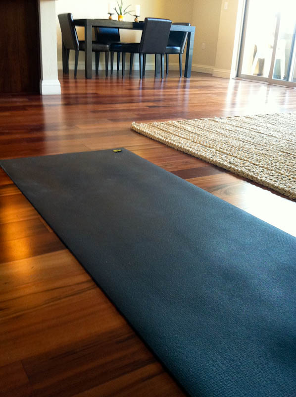 black yoga mat on hardwood floors