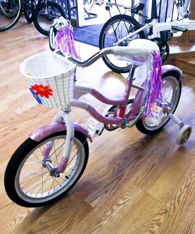 Pink bicycle with white basket and pink and white streamers