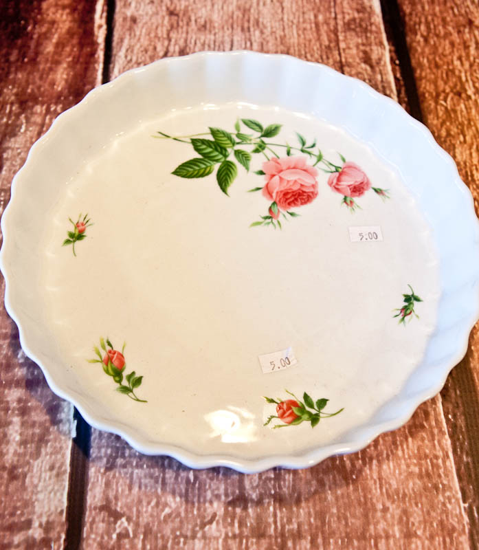 White pan with pink flowers and stems