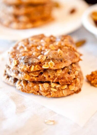 A stack of homemade oatmeal cookies on a white surface.